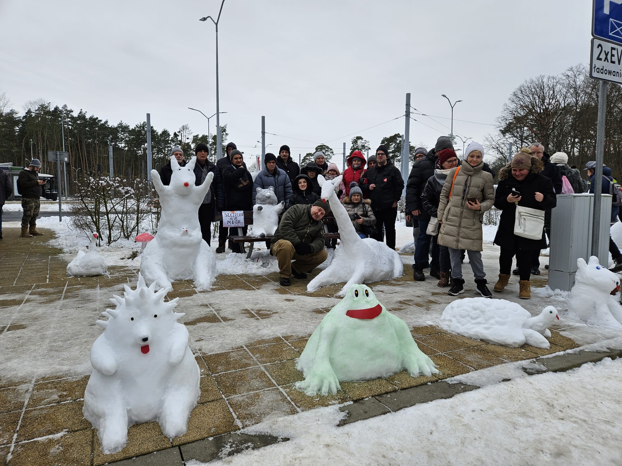 Grupa osób na tle śniegowych rzeźb.