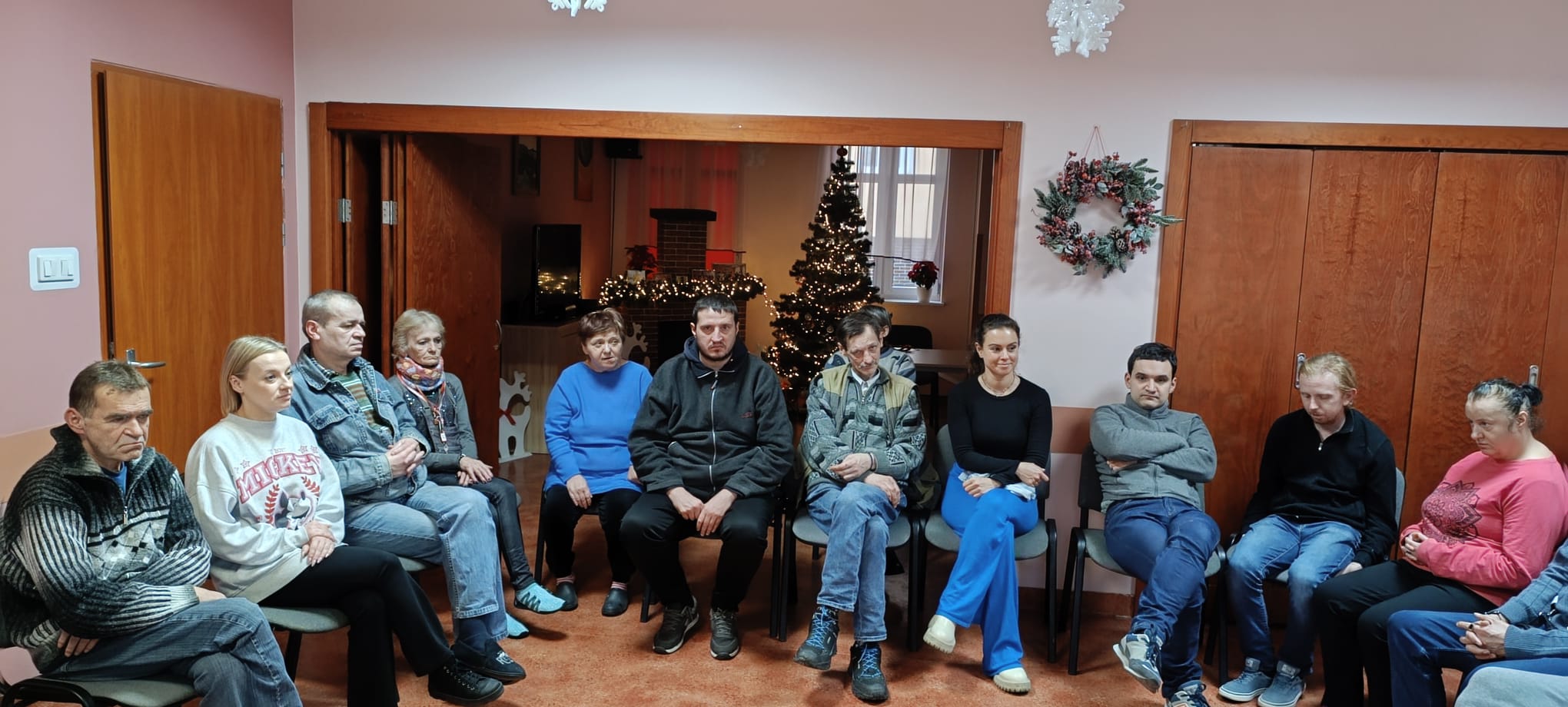 Grupa osób siedzi w kręgu 