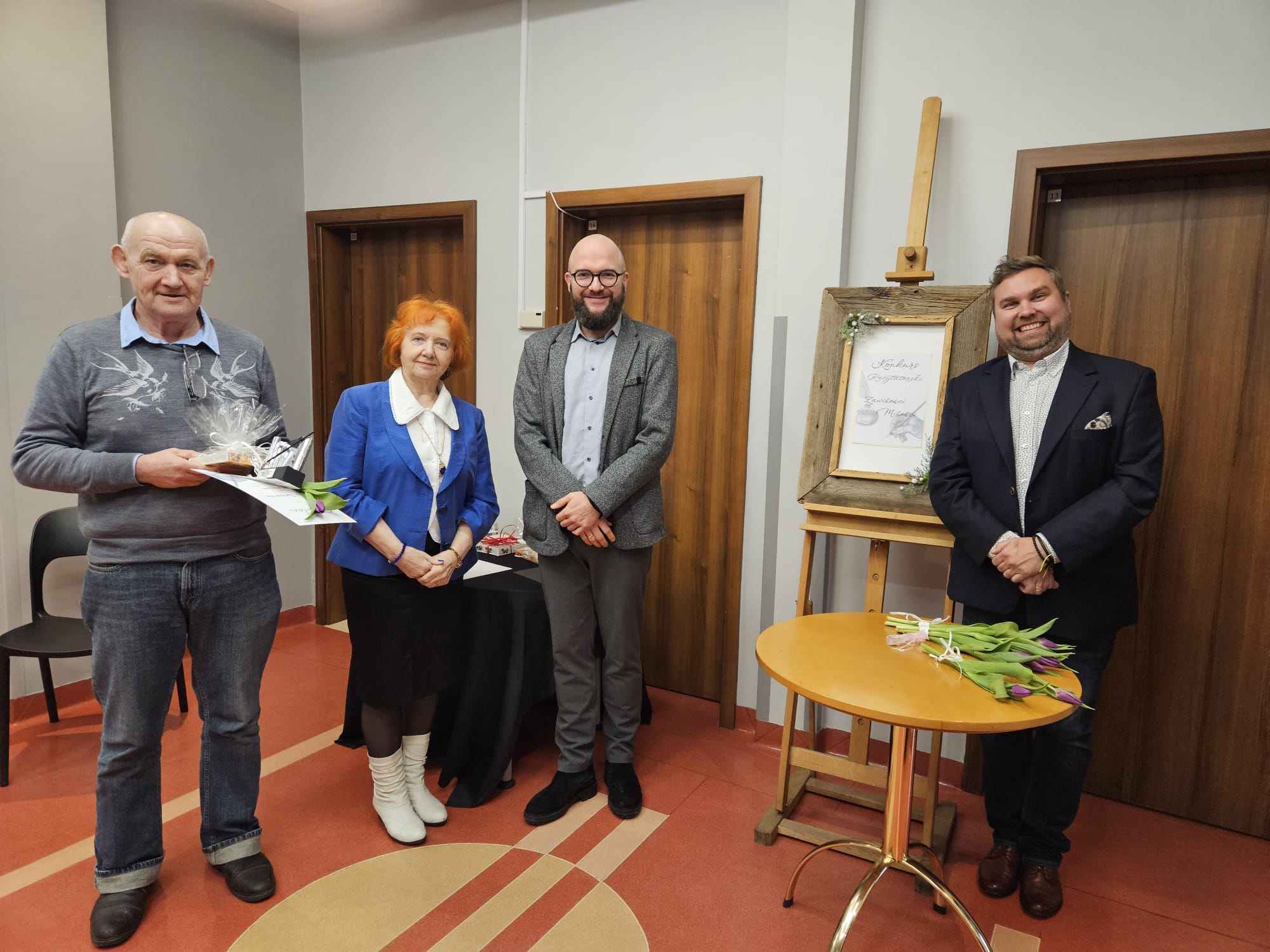 Grupa jurorów z nagrodzonym laureatem