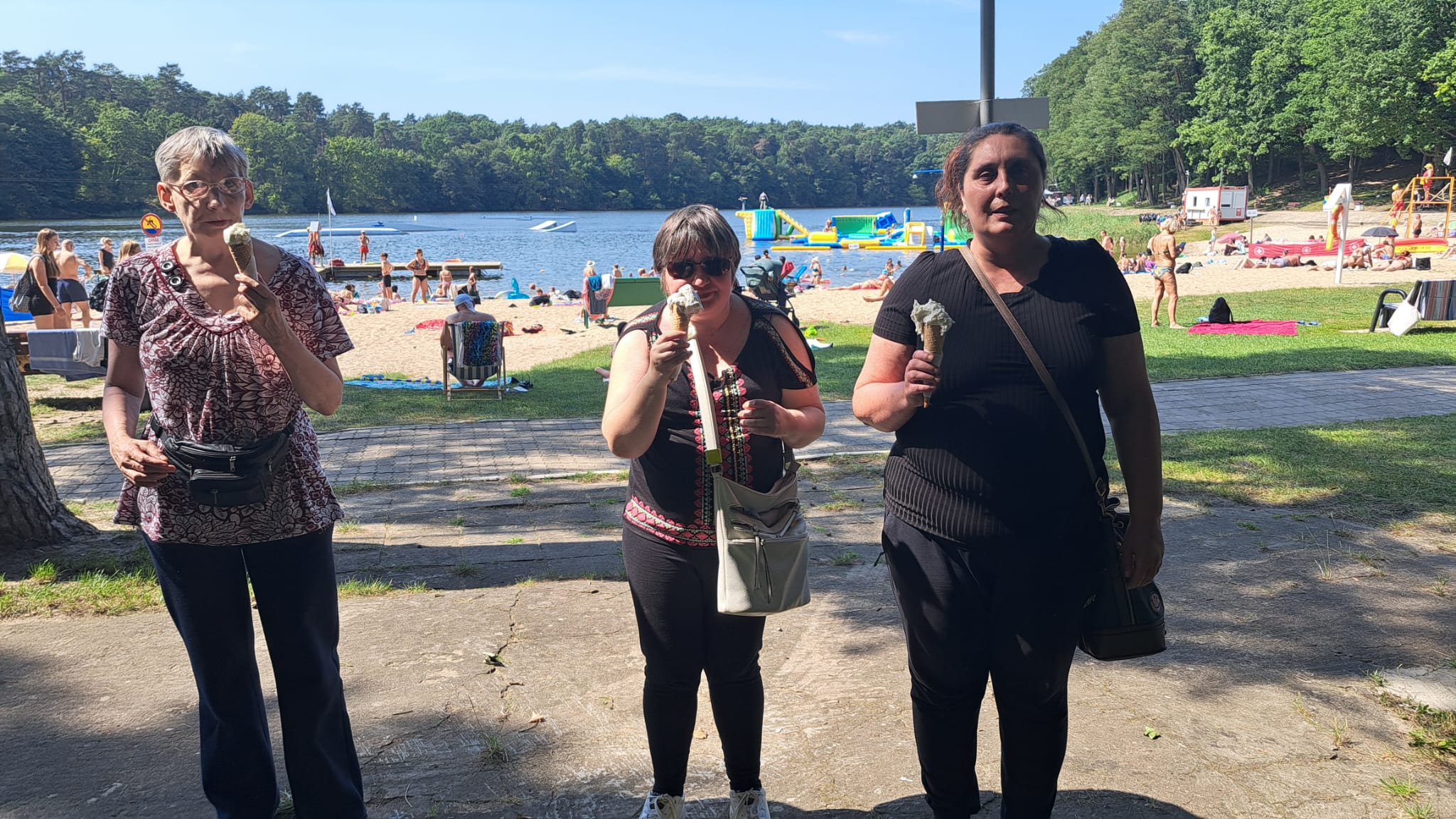 Grupa osób stoi na tle wody.