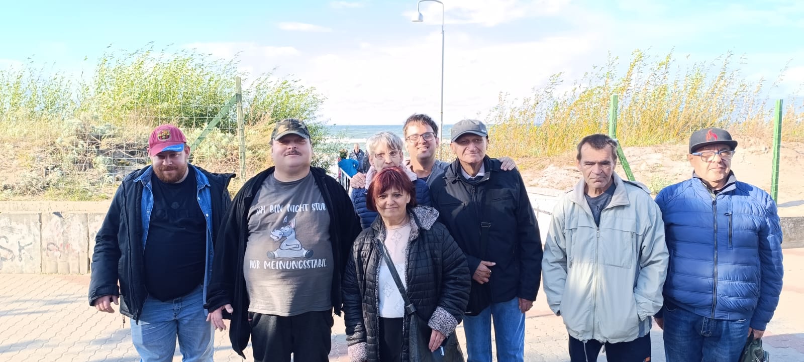 Grupa osób na tle wzburzonych fal Bałtyku.