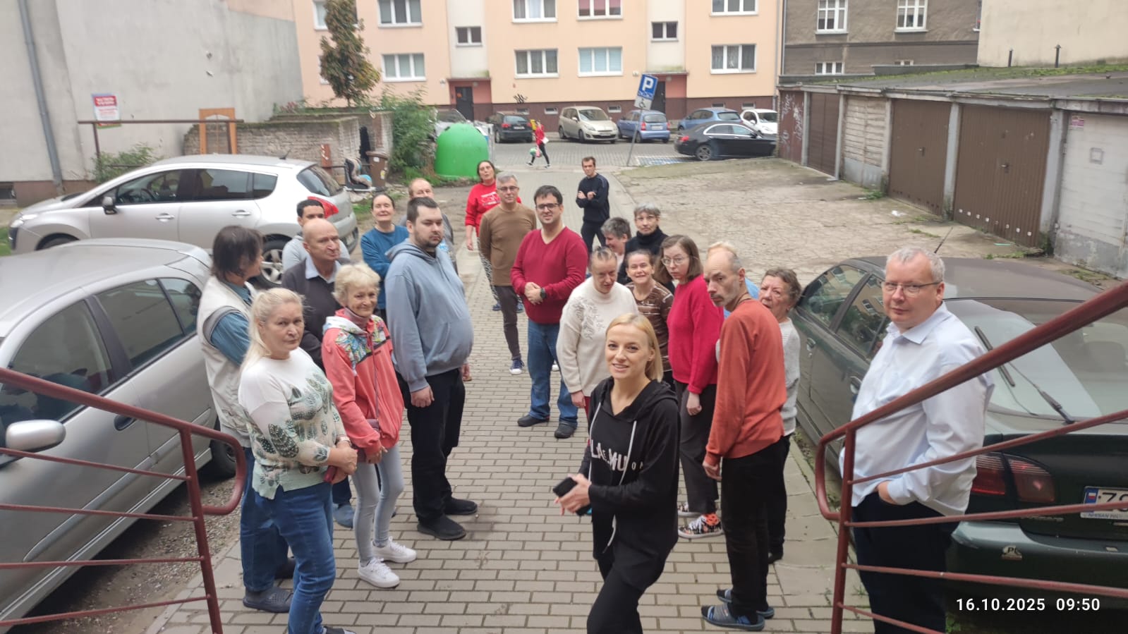 Grupa osób przed schodami ośrodka,w trakcie ćwiczeń przeciwpożarowych.