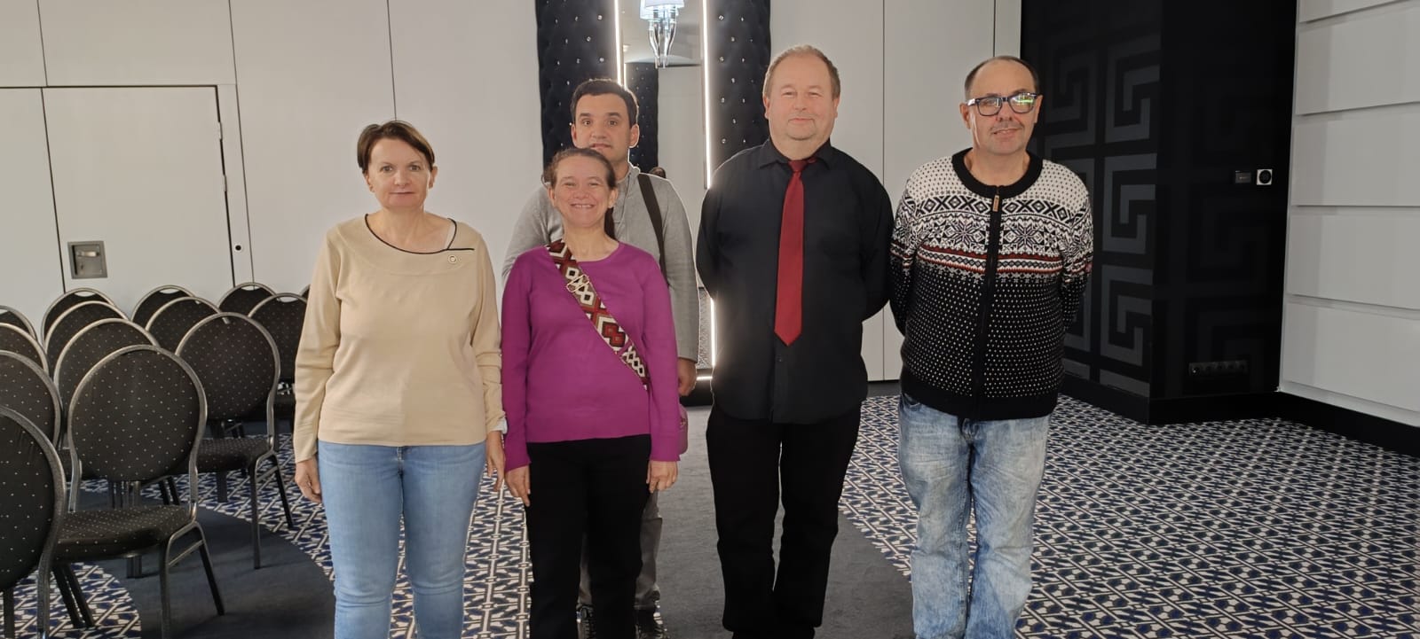 Grupa osób pozuje do zdjęcia w sali koncertowej Hanza Tower.