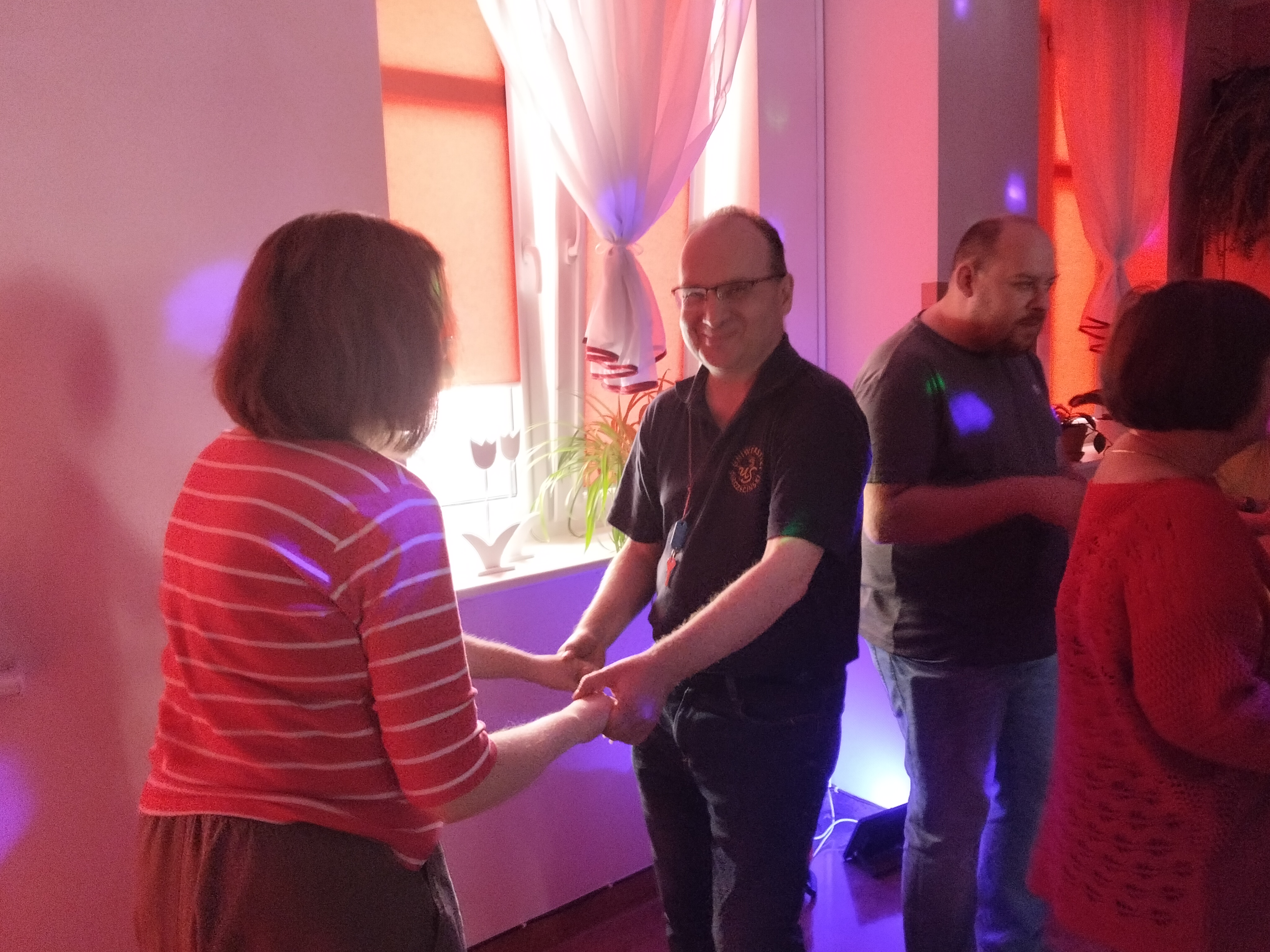 Pani z panem tańczą. W tle kolorowe światła.