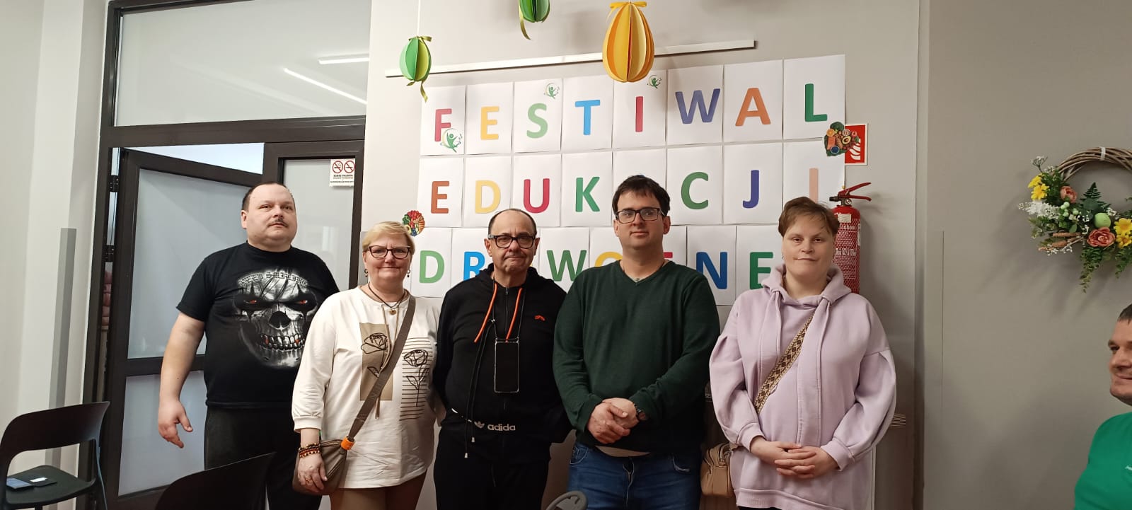 Grupa osób pozuje na ściance reklamowej festiwalu.