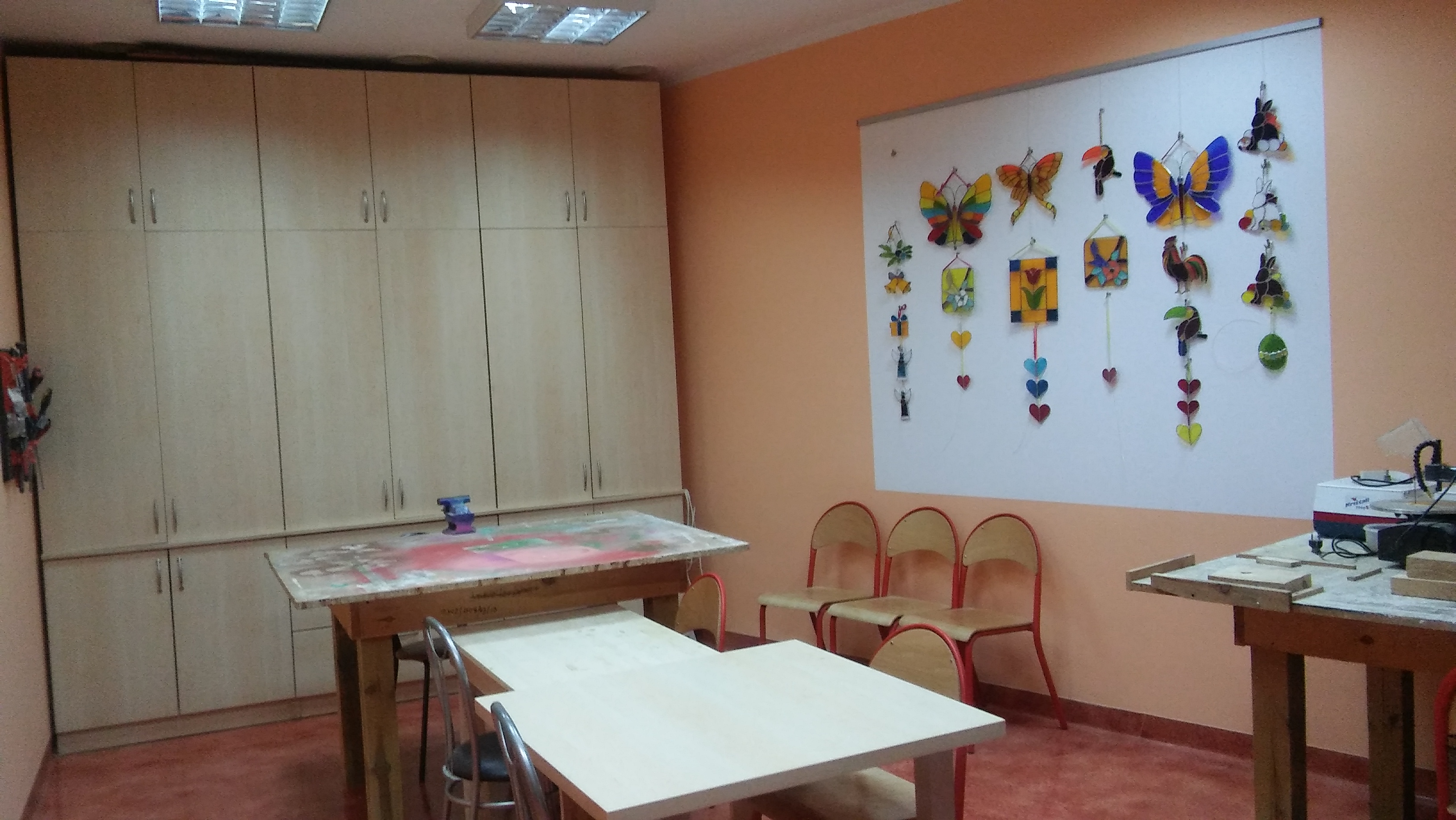 Pracownia stolarsko witrażowa. Na ścianie znajdują się witraże ze szkła dekoracyjnego.