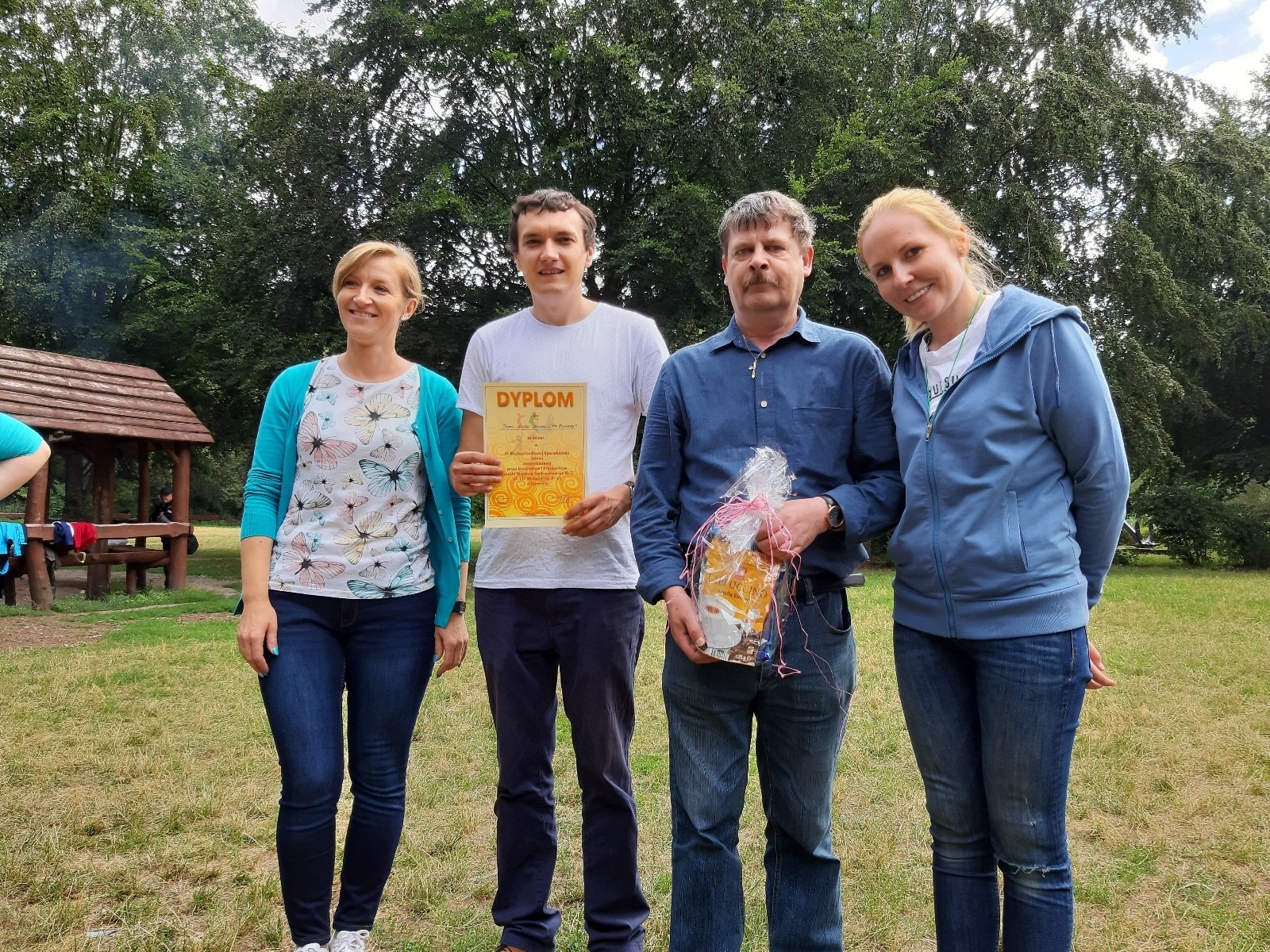 Dwie kobiety i dwóch mężczyzn podczas wręczenia dyplomów i nagród. 