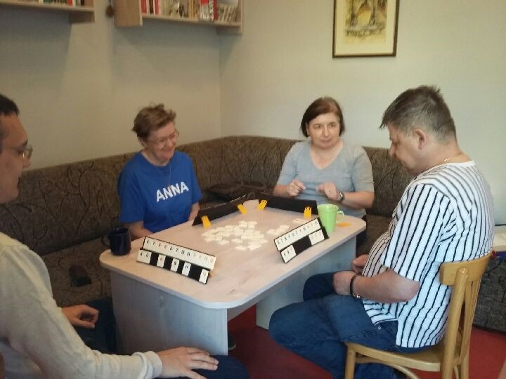 Dwóch mężczyzn i dwie kobiety podczas gry w „Rummikub”.