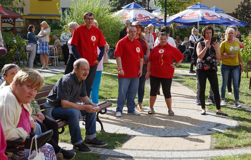 Grupa kobiet i mężczyzn w ogrodzie podczas pikniku z okazji festiwalu bajek. 