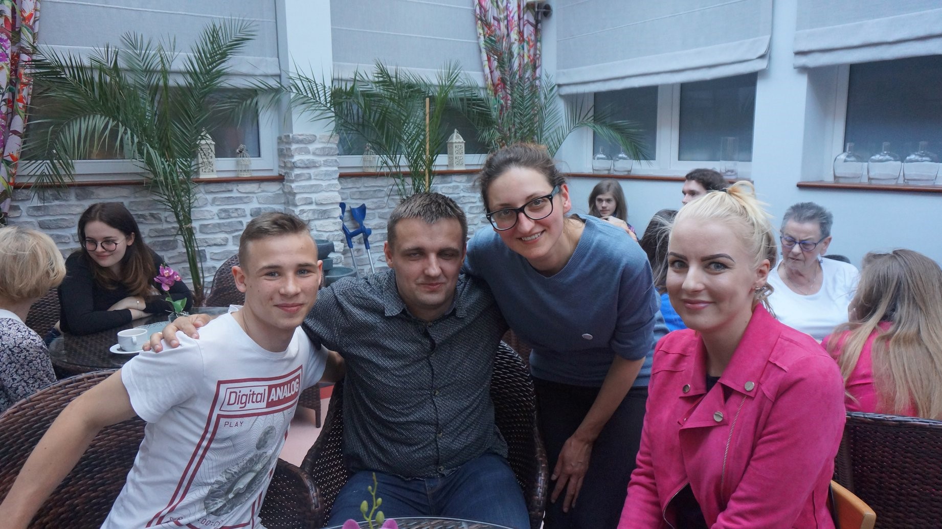 Grupa ludzi podczas spotkania w kawiarence klubowej promującego wolontariat. 