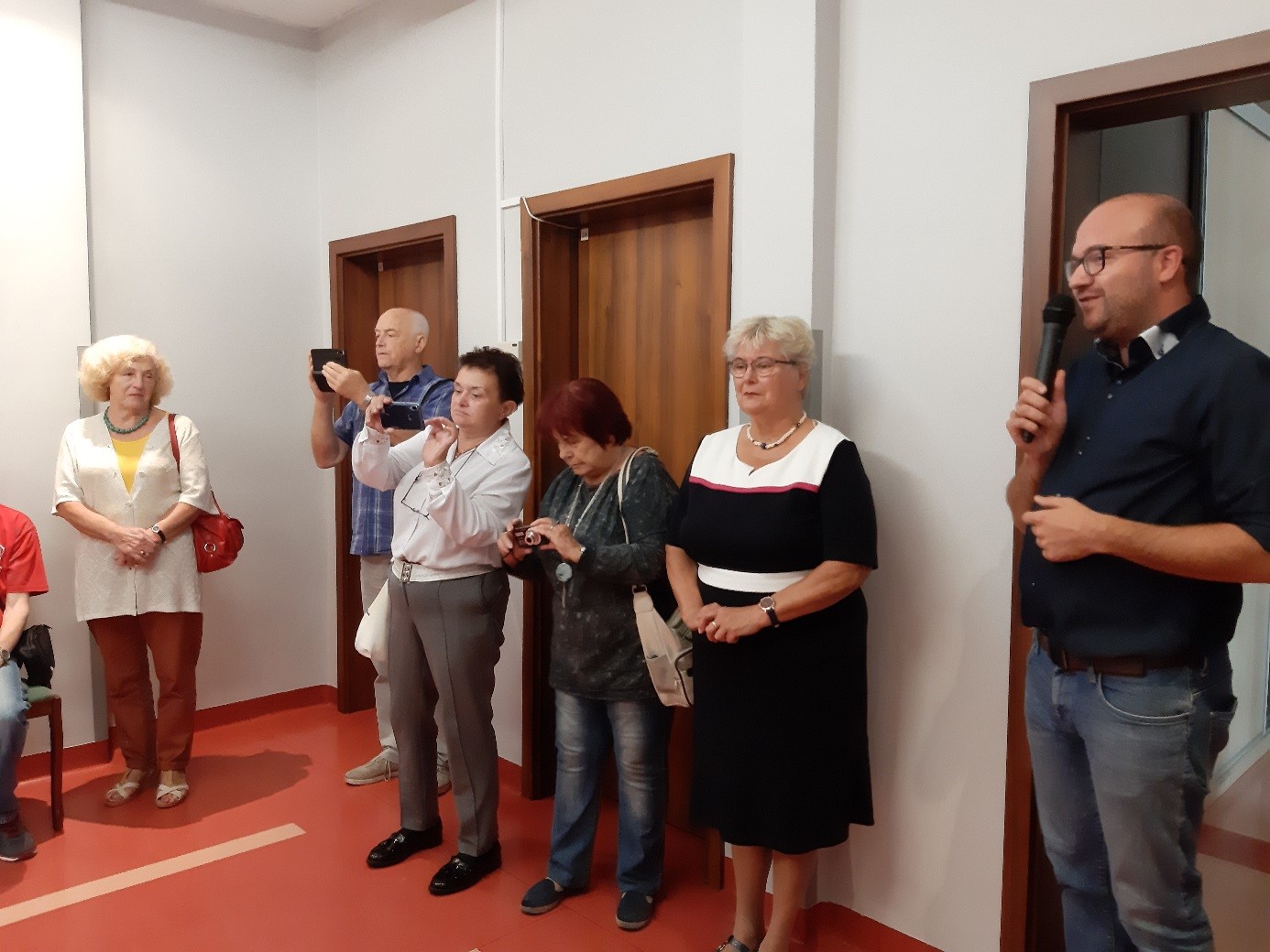 Grupa uczestników wernisażu podczas oficjalnych przemówień. 