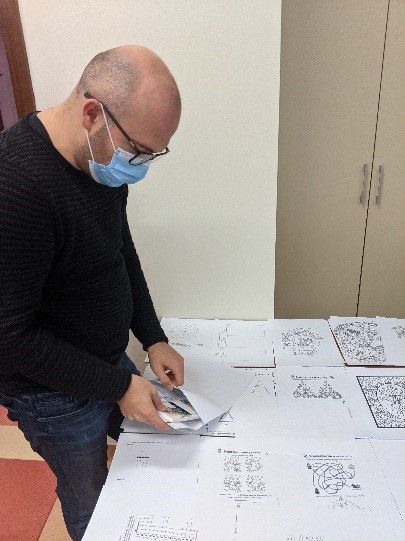 Mężczyzna pakuje materiały edukacyjne do kopert.
