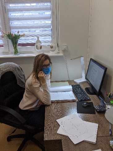 Siedząca przy biurku kobieta rozmawia przez telefon.