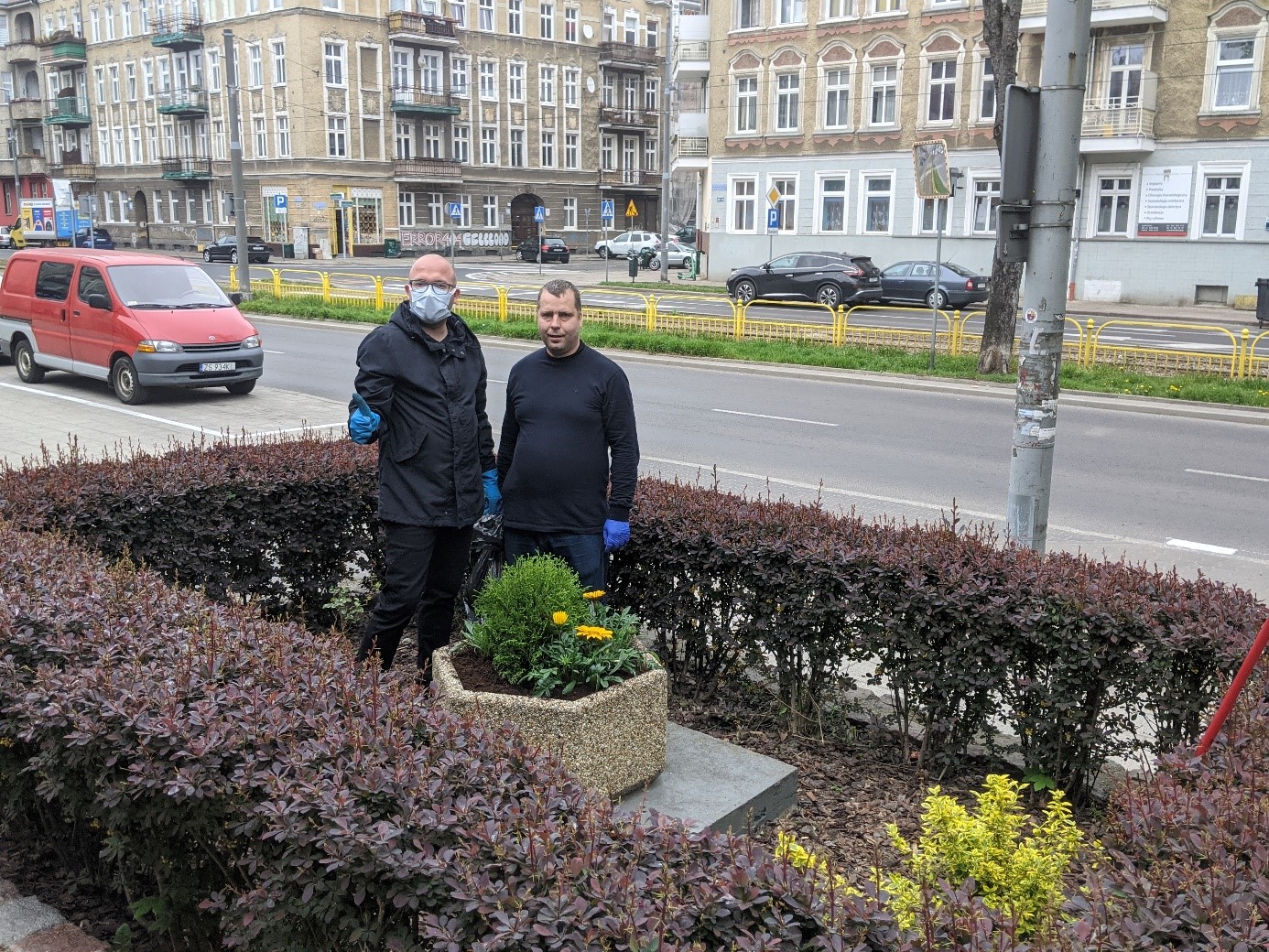 Dwóch mężczyzn podczas sadzenia roślin doniczkowych. 