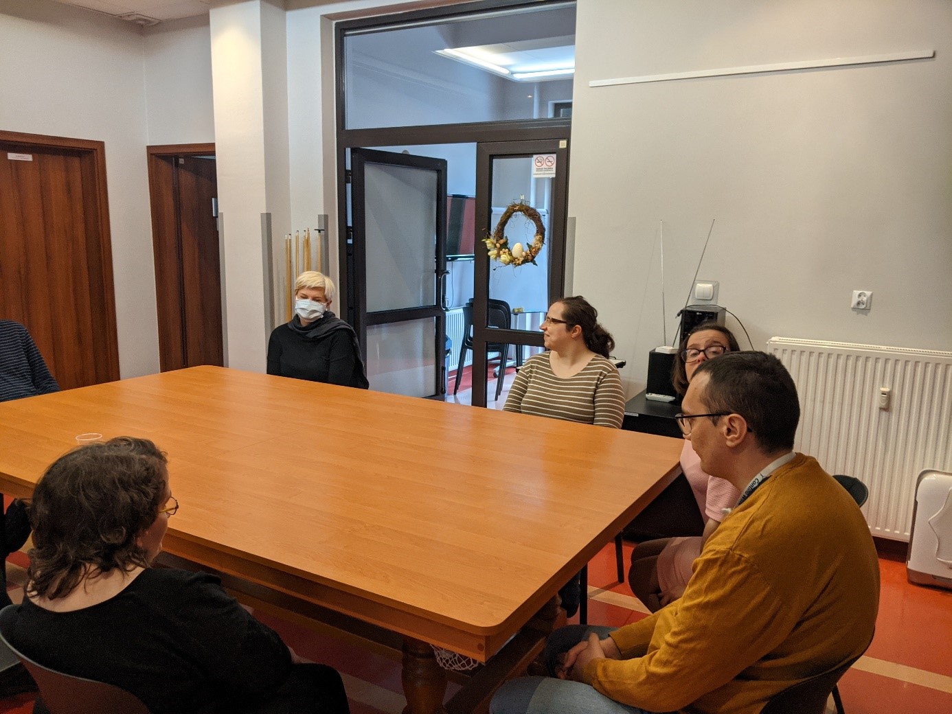 Terapeutka prowadzi zajęcia z grupą słuchaczy.