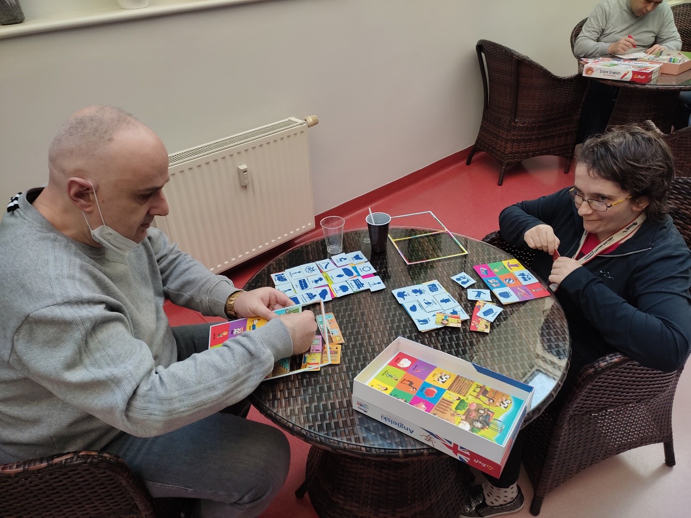 Kobieta i mężczyzna grają w grę do nauki języka angielskiego.