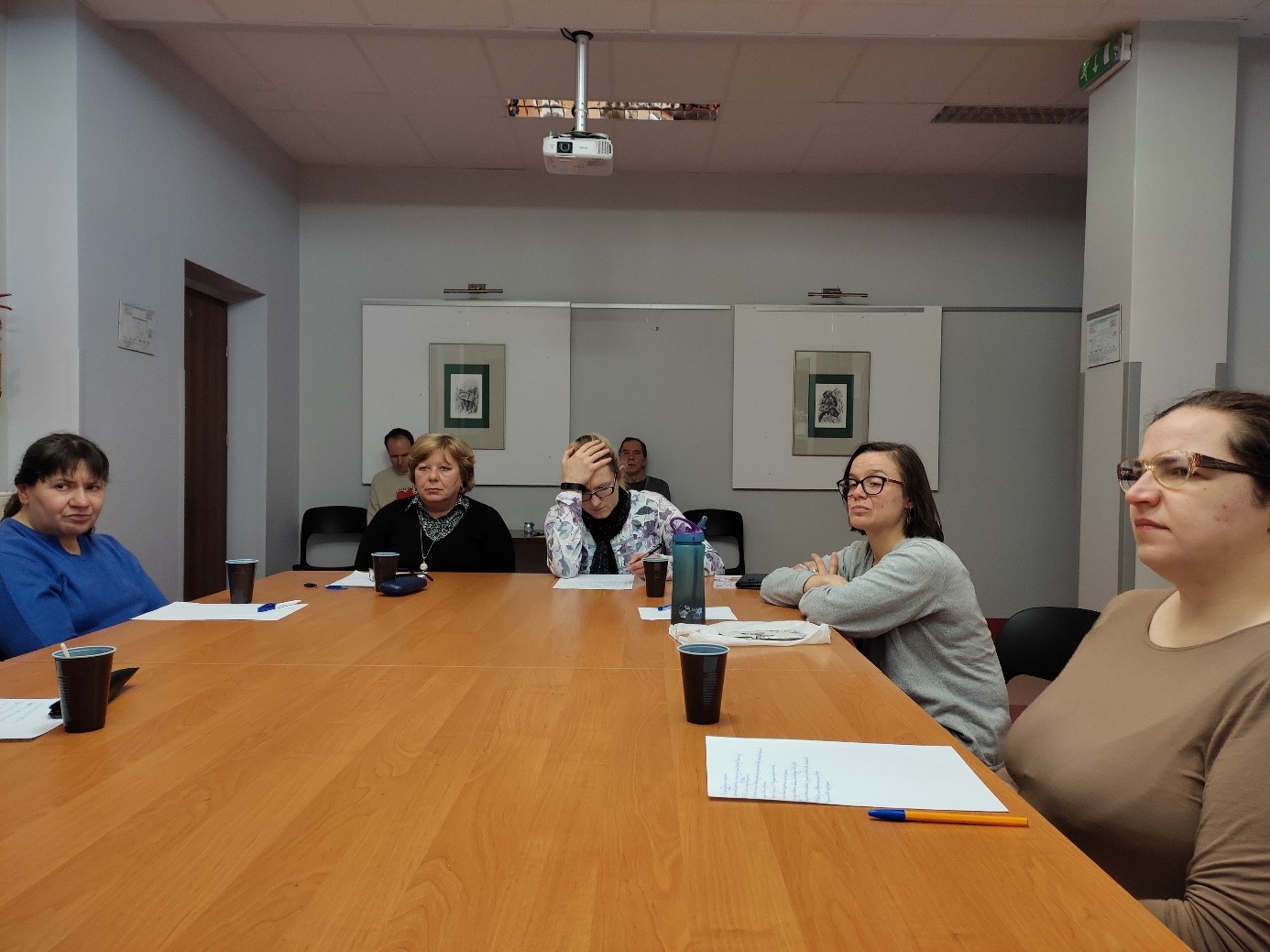 Grupa kobiet i mężczyzn podczas zajęć terapeutycznych.