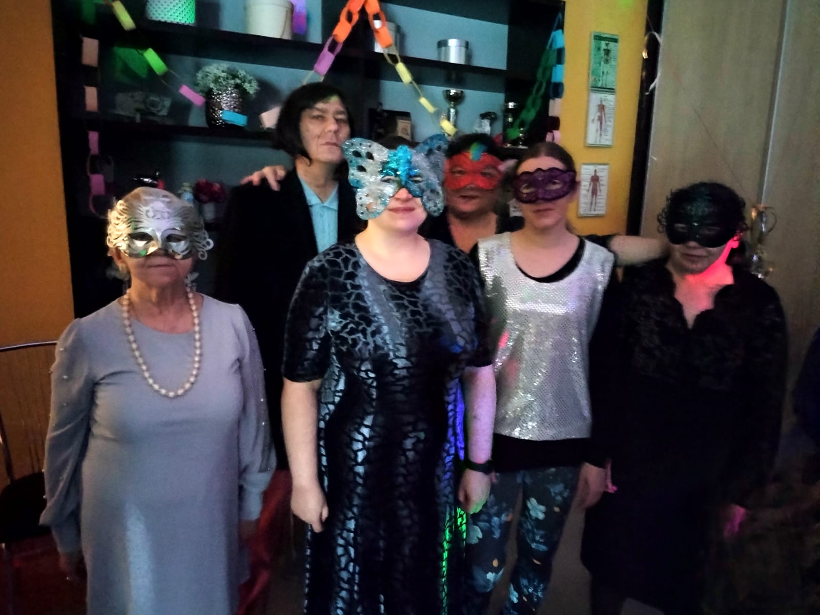 Grupa osób w strojach i maskach karnawałowych. 