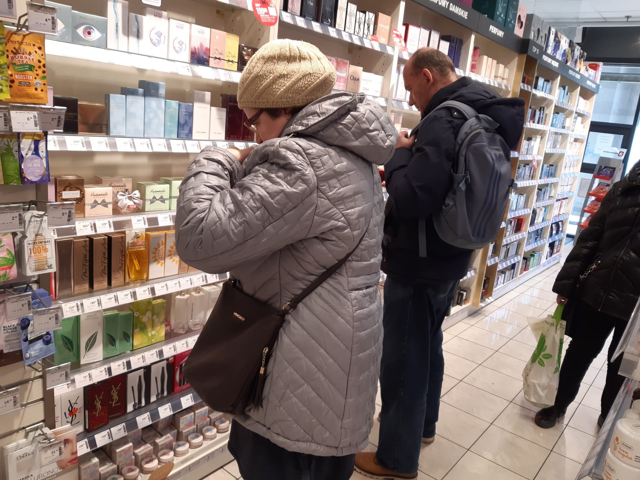 Kobieta i mężczyzna przy regale z kosmetykami. 