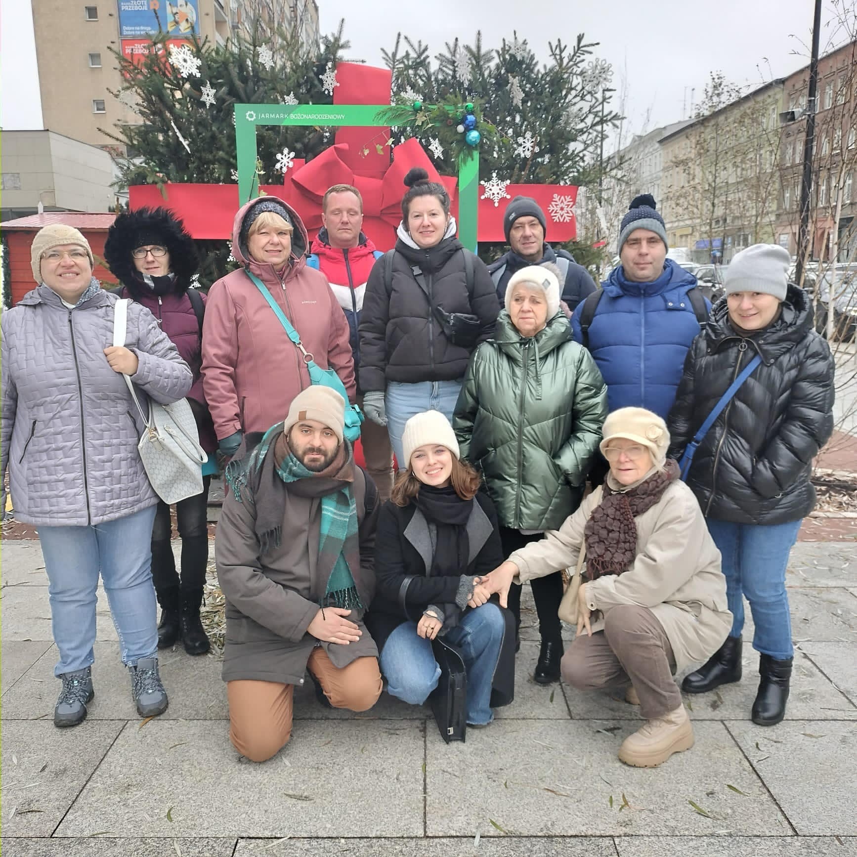 Grupa ludzi pozująca na tle świątecznej dekoracji