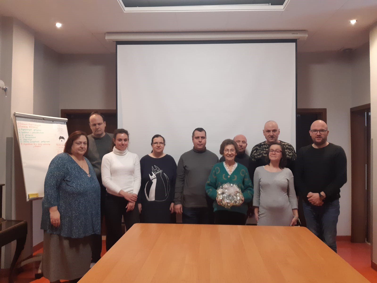 Grupa osób pozująca do zdjęcia. W tle biały ekran. 