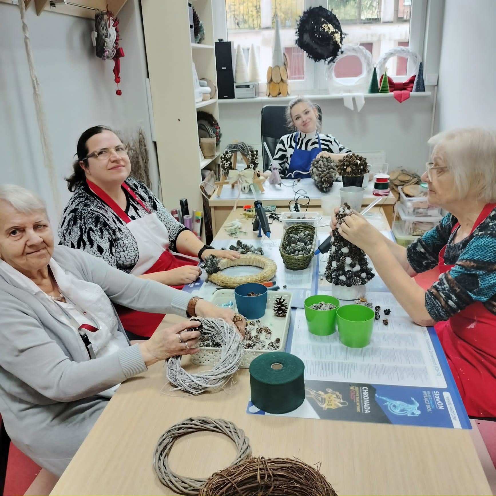 Cztery kobiety tworzące dekoracje świąteczne.