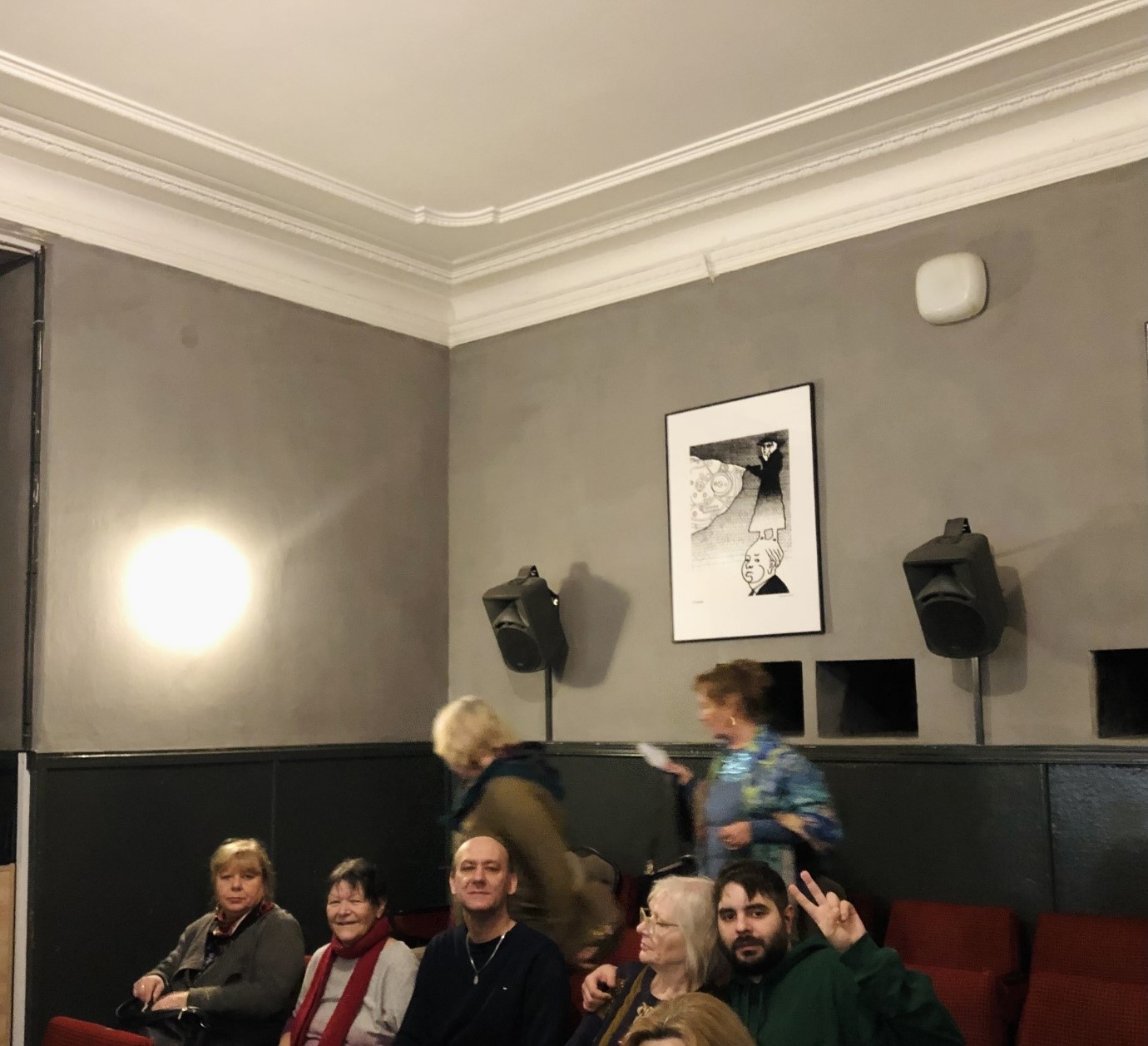 Grupa osób siedząca w sali kinowej;