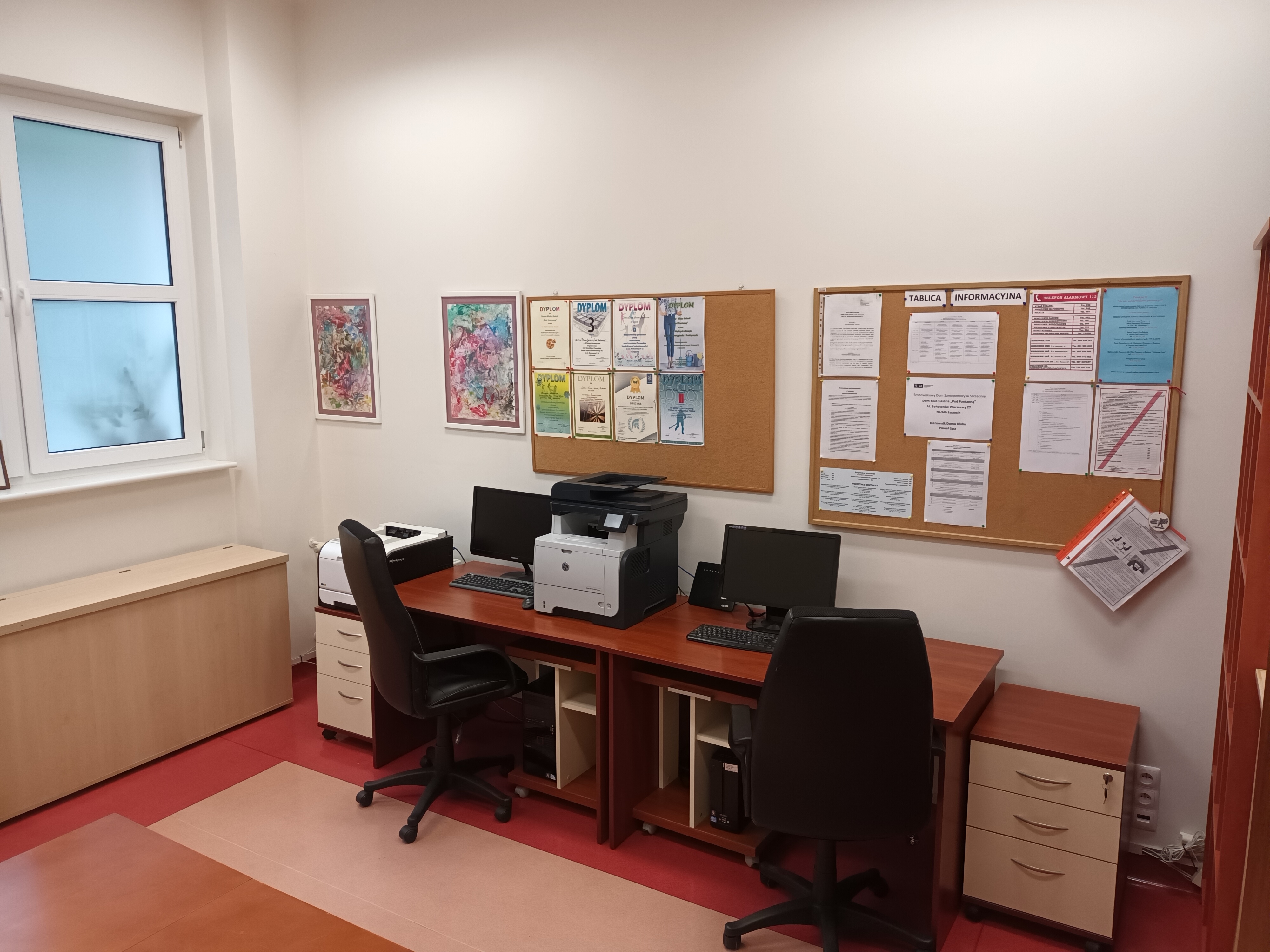 Pomieszczenie biurowe z komputerami oraz drukarką