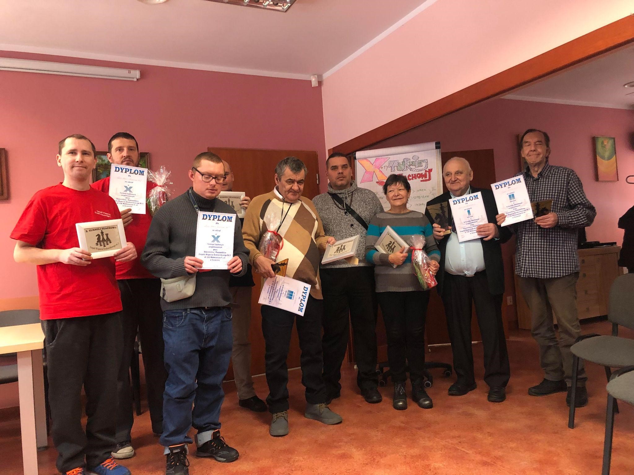 Grupa osób pozująca z dyplomami .