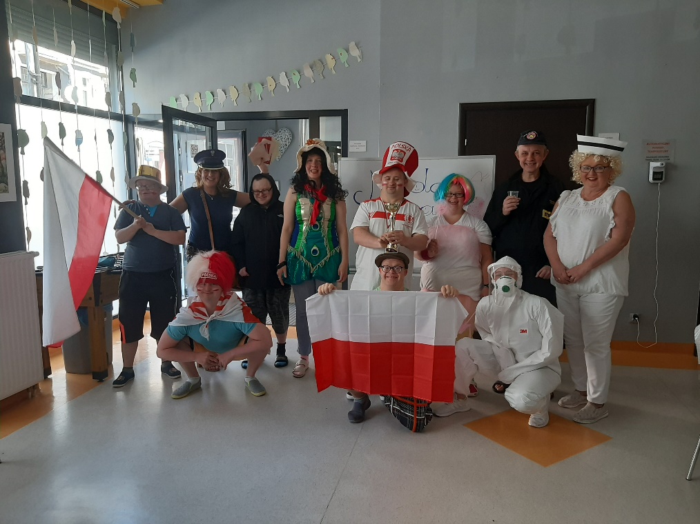 Grupa osób w kolorowych strojach między innymi strażaka, pielęgniarki, listonoszki.