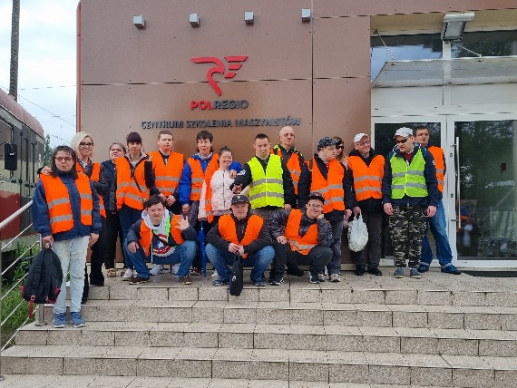 Grupa kobiet i mężczyzn stoi  na schodach.