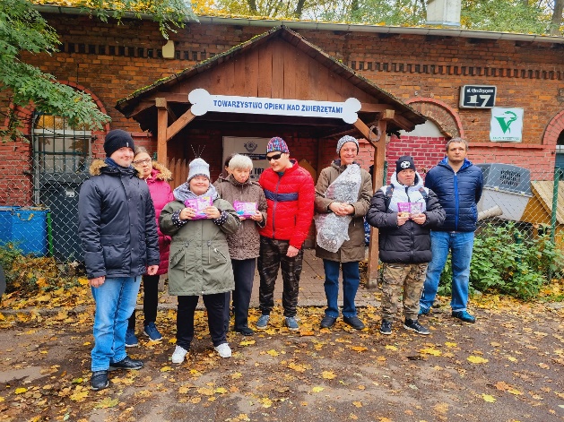 Kobiety i mężczyźni stoją i patrzą w obiektyw aparatu fotograficznego.