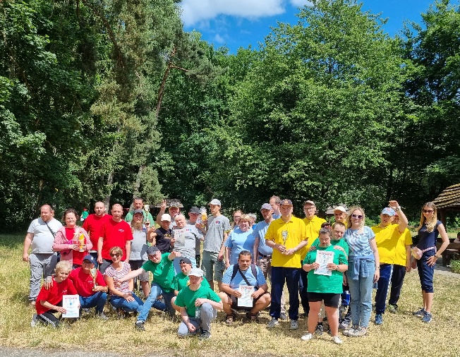 Kobiety i mężczyźni stoją i patrzą w obiektyw aparatu fotograficznego.