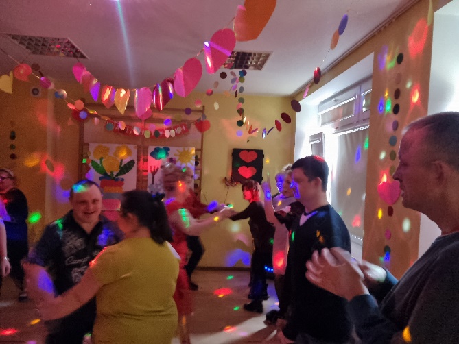 Kobiety i męzczyźni tańczą.