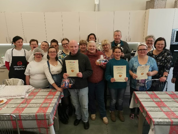 Kobiety i mężczyźni stoją i patrzą w obiektyw aparatu fotograficznego.