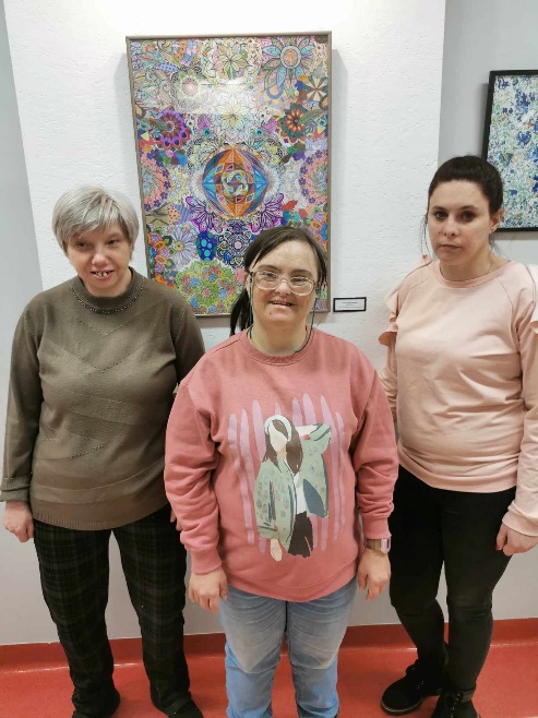 Kobiety stoją i patrzą w obiektyw aparatu fotograficznego.