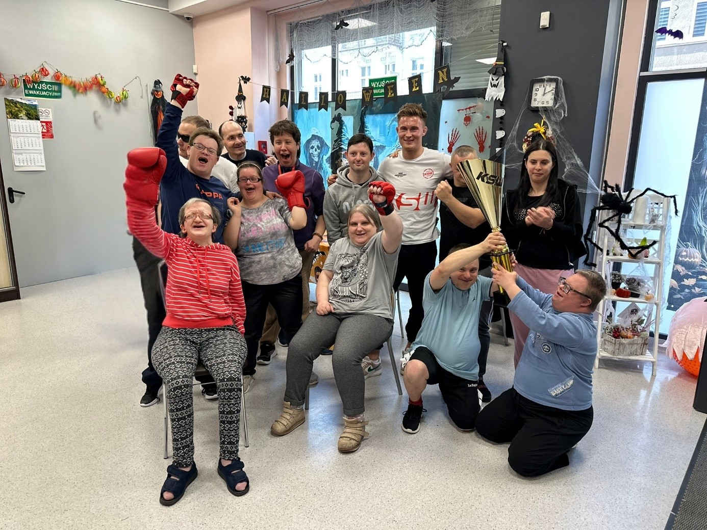 Grupa kobiet i mężczyzn pozuje do zdjęcia. Dwóch mężczyzn trzyma puchar. 
