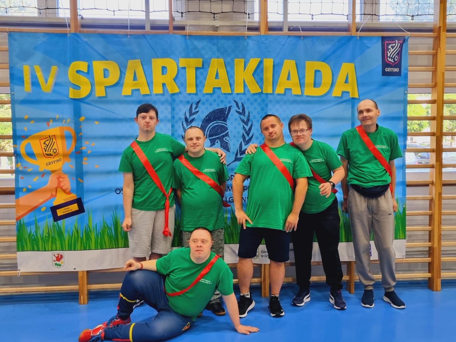 Sześciu mężczyzn pozuje do zdjęcia. W tle baner informacyjny. 