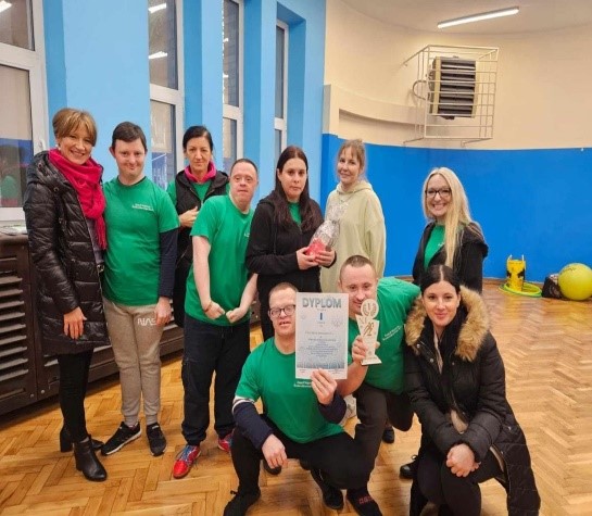 Kobiety i mężczyźni stoją i patrzą w obiektyw aparatu fotograficznego.