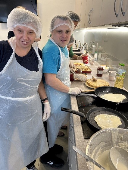 Kobieta i mężczyzna  smażący naleśniki. 